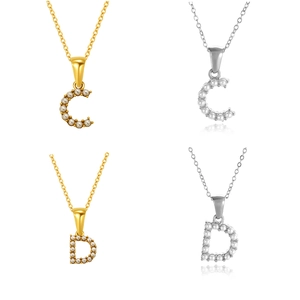 Detalle de colgantes de letras C y D con perlas en acabados dorado y plateado
