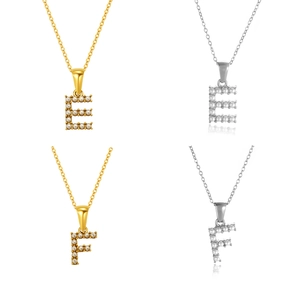 Detalle de colgantes de letras E y F con perlas de imitación en acabados oro y plata