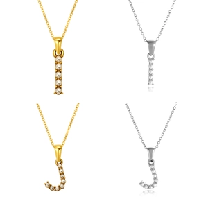 Detalle de colgantes de letras I y J con incrustaciones de perlas en oro y plata