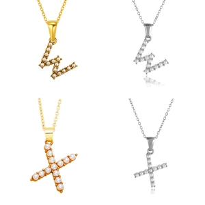 Detalle de los colgantes de letras con perlas de imitación en acabados oro y plata