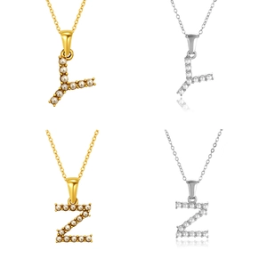 Detalle de los collares L y Z con incrustaciones de perlas en acabados oro y plata