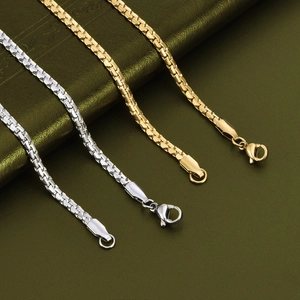 Detailed close-up of gold and silver box chain necklaces with lobster clasps