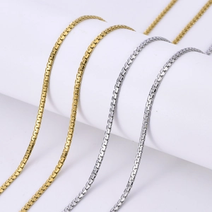 Macro detail of minimalist gold and silver stainless steel box chains on a display stand