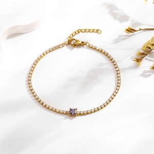 Detail of gold tennis bracelet with white zircon and purple square gemstone