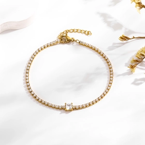 Close-up of gold tennis bracelet with a central square zircon and adjustable lobster clasp