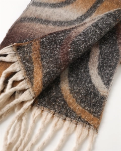 Close-up of wavy knit patterns and handmade tassels on soft cashmere-like scarf