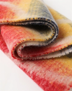 Close-up of thick rainbow plaid scarf with soft cashmere-like texture and fringed details