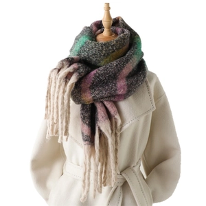 Rainbow plaid cashmere scarf with tassels styled on a white coat for winter