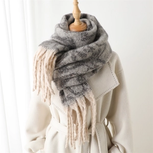 Detail of grey and white checkered faux cashmere scarf with elegant fringe tassels