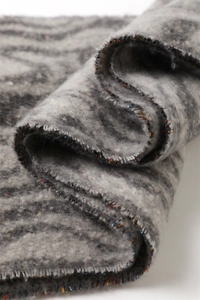 Close-up of geometric grey cashmere-like scarf with fringe detail and thick texture