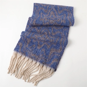 Detail of dark blue geometric knit scarf with soft cashmere-like texture and white tassels