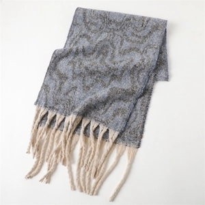 Close-up of geometric pattern knit scarf featuring thick cream fringe tassels