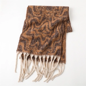 Detail of cashmere-feel scarf with orange wave patterns and cream white tassels
