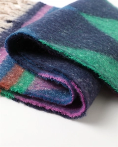Detailed macro view of soft cashmere-like geometric scarf with thick fringes and bold colors