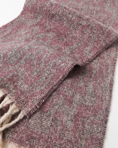 Detailed knit texture of wavy geometric pattern scarf with long cream tassels