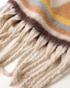Close-up of geometric cashmere-like scarf with soft fringe tassels in warm earth tones