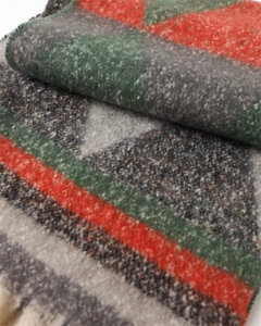 Close-up of geometric triangle pattern on thick faux cashmere winter shawl with fringe