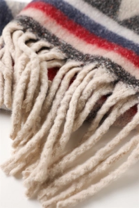 Detailed close-up of thick geometric knit scarf with fringe and colorful stripe pattern