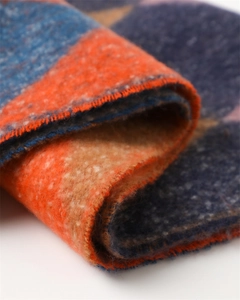 Close-up of thick geometric color-block knit scarf with soft plush texture and tassels