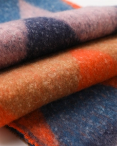 Macro detail of thick faux cashmere scarf with blue and orange geometric patterns