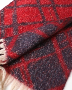 Close-up of red and navy plaid scarf featuring soft cashmere-like texture and cream fringe