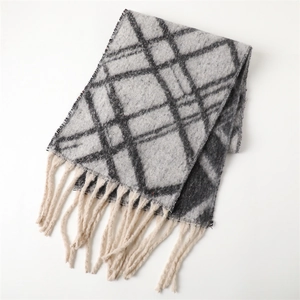 Detailed close-up of grey and black plaid cashmere scarf with soft fringe tassels
