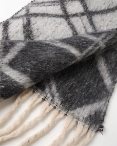 Macro shot of plaid scarf detail with brushed texture and off-white tassel fringe