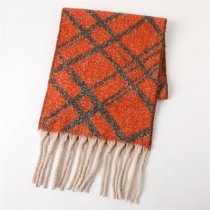 Detail view of orange and grey plaid scarf with soft thick cream tassels and warm texture