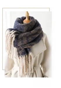 Détail d'une écharpe en maille géométrique bleue et marron avec de longues franges