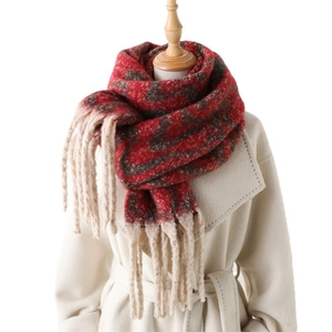 Red and grey geometric pattern pashmina scarf with long tassels on a white coat display