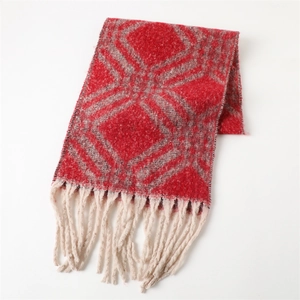 Vue détaillée du motif géométrique rouge et des pompons blanc crème sur l'écharpe