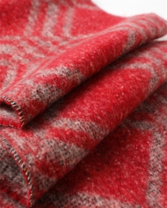 Vue macro d'une écharpe rouge effet cachemire avec des motifs géométriques gris épais