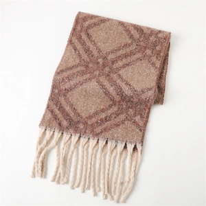 Détail du motif géométrique à losanges et glands beige sur l'écharpe bleu marine et marron