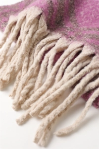 Gros plan détaillé de l'écharpe en cachemire à carreaux rose et gris avec franges blanches