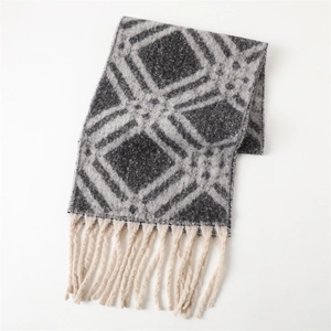 Détail du motif géométrique gris sur écharpe en cachemire avec pompons ivoire