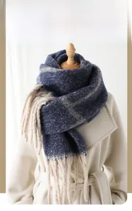 Classic blue and beige plaid cashmere scarf with long tassels on a beige wool coat