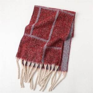 Detailed view of thick plaid scarf featuring soft cashmere-like texture and cream tassel fringe