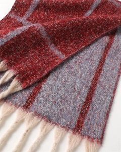 Close-up of classic plaid scarf texture showing thick woven fabric and cream fringe detail