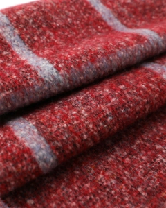 Macro shot of deep red plaid scarf showing soft cashmere-like texture and thick fabric