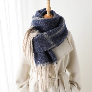 Classic plaid imitation cashmere scarf with tassels, styled on a white coat and wooden stand