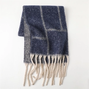 Detail view of the soft plaid pattern scarf and beige tassels on the thick knit fabric