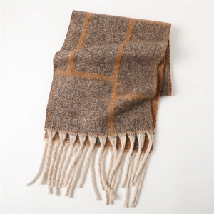 Detailed view of plaid cashmere-like winter scarf featuring neutral tones and orange accents