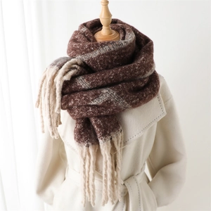 Classic plaid imitation cashmere scarf with tassels on wooden mannequin over beige coat