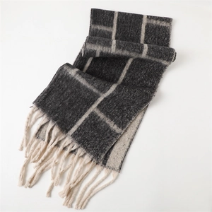 Detail of charcoal grey and beige checkered scarf with long twisted fringe edges