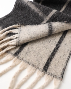 Close-up of thick grey and white plaid scarf with soft cashmere-like texture and tassels