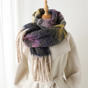Detail shot of colorful zigzag pattern scarf with long tassels on a cashmere coat