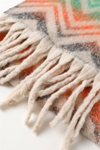 Detailed macro view of vibrant zigzag pattern and soft fringe on cashmere-like scarf