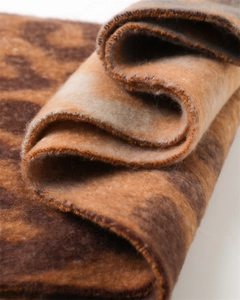 Macro shot of soft leopard print scarf featuring thick cashmere-like texture and warm brown tones