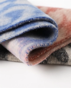 Close-up of soft cashmere-like scarf showing gradient leopard patterns and fringe edges
