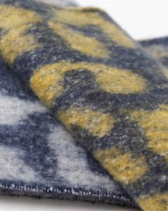 Macro shot of fuzzy leopard print scarf fabric showing soft brushed texture and vibrant colors